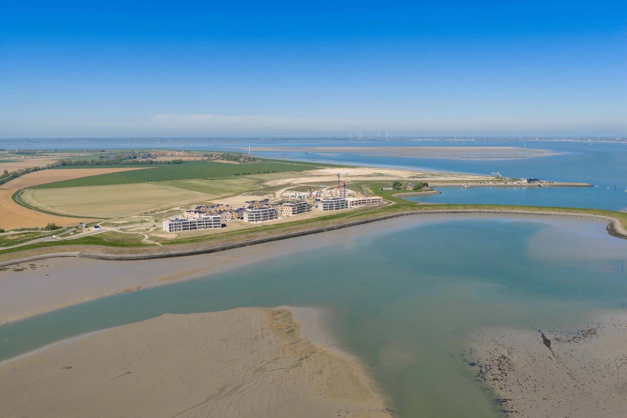 Luchtfoto van de appartementen van Waterzande aan de Veerdijk, met de Westerschelde eromheen